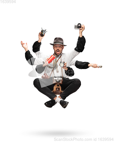 Image of Handsome multi-armed journalist levitating isolated on yellow studio background with equipment