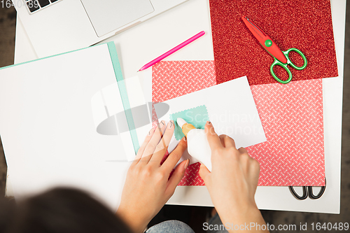 Image of Woman making greeting card for New Year and Christmas 2021 for friends or family, scrap booking, DIY