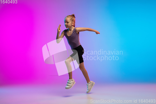 Image of Teenage girl running, jogging against gradient pink-blue neon studio background in motion