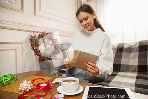 Image of Woman opening, recieving greeting card for New Year and Christmas 2021 from friends or family