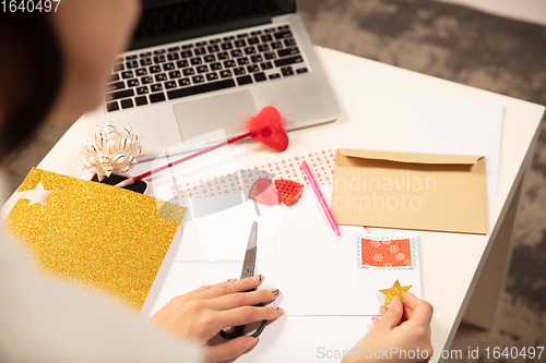 Image of Woman making greeting card for New Year and Christmas 2021 for friends or family, scrap booking, DIY