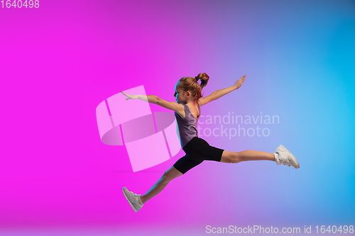 Image of Teenage girl running, jogging against gradient pink-blue neon studio background in motion