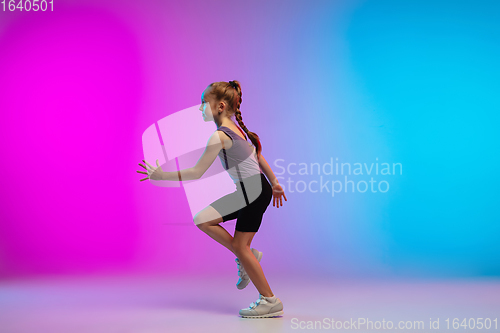 Image of Teenage girl running, jogging against gradient pink-blue neon studio background in motion
