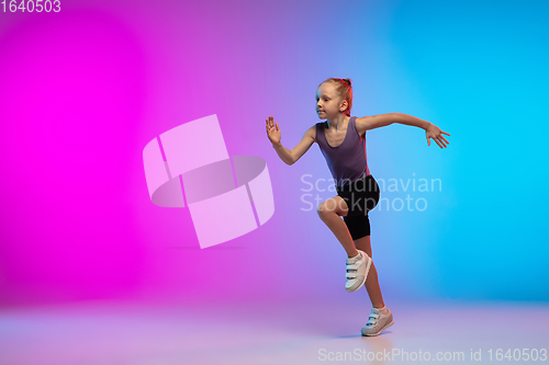 Image of Teenage girl running, jogging against gradient pink-blue neon studio background in motion