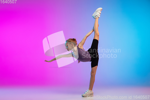 Image of Teenage girl running, jogging against gradient pink-blue neon studio background in motion