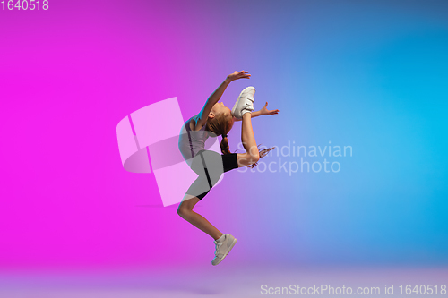 Image of Teenage girl running, jogging against gradient pink-blue neon studio background in motion