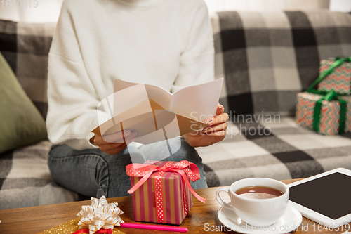 Image of Woman opening, recieving greeting card for New Year and Christmas 2021 from friends or family