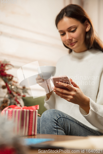 Image of Woman writing message, greetings for New Year and Christmas 2021 for friends or family with her cellphone