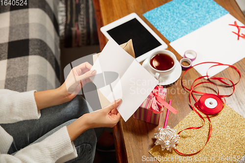 Image of Woman opening, recieving greeting card for New Year and Christmas 2021 from friends or family