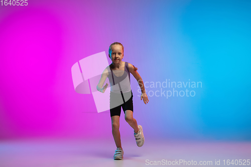 Image of Teenage girl running, jogging against gradient pink-blue neon studio background in motion