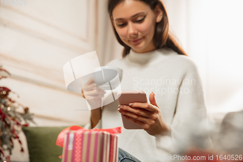 Image of Woman writing message, greetings for New Year and Christmas 2021 for friends or family with her cellphone