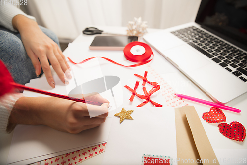 Image of Woman making greeting card for New Year and Christmas 2021 for friends or family, scrap booking, DIY