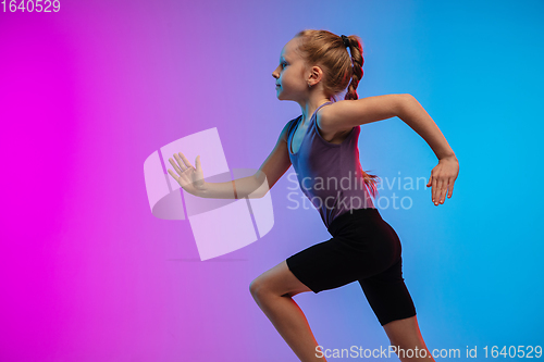 Image of Teenage girl running, jogging against gradient pink-blue neon studio background in motion