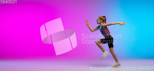 Image of Teenage girl running, jogging against gradient pink-blue neon studio background in motion