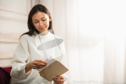 Image of Woman opening, recieving greeting card for New Year and Christmas 2021 from friends or family