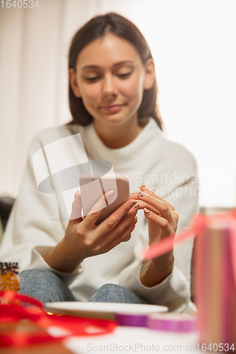 Image of Woman writing message, greetings for New Year and Christmas 2021 for friends or family with her cellphone