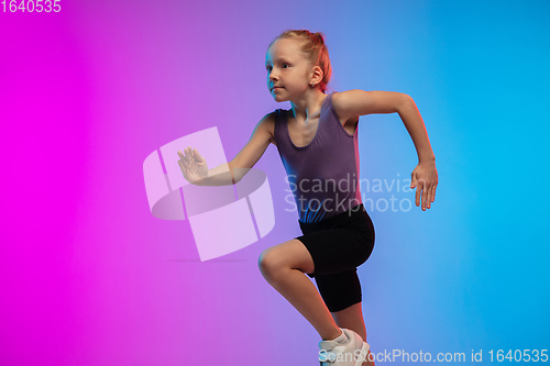 Image of Teenage girl running, jogging against gradient pink-blue neon studio background in motion