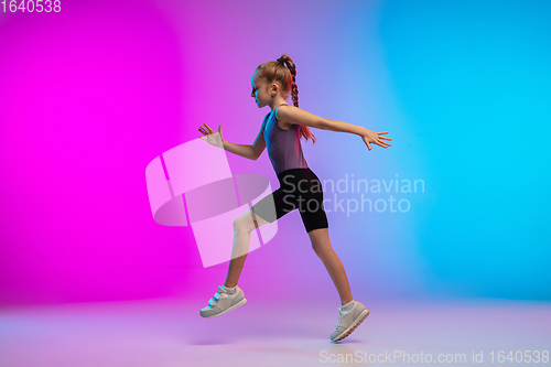 Image of Teenage girl running, jogging against gradient pink-blue neon studio background in motion