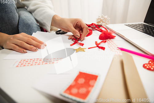 Image of Woman making greeting card for New Year and Christmas 2021 for friends or family, scrap booking, DIY