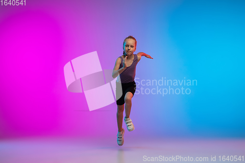 Image of Teenage girl running, jogging against gradient pink-blue neon studio background in motion