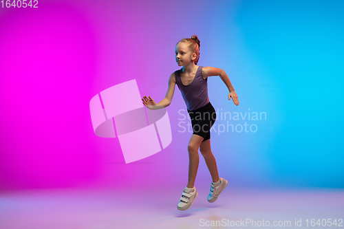 Image of Teenage girl running, jogging against gradient pink-blue neon studio background in motion