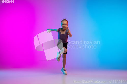 Image of Teenage girl running, jogging against gradient pink-blue neon studio background in motion