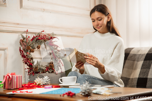 Image of Woman opening, recieving greeting card for New Year and Christmas 2021 from friends or family