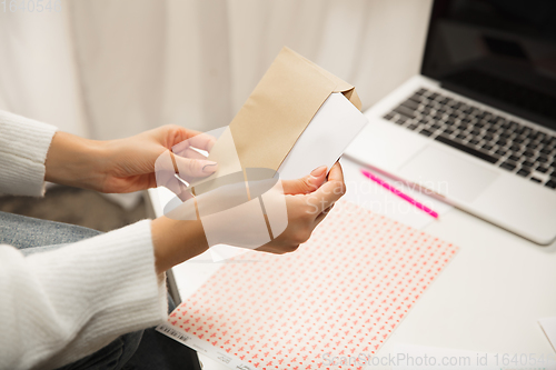 Image of Woman opening, recieving greeting card for New Year and Christmas 2021 from friends or family