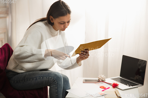 Image of Woman opening, recieving greeting card for New Year and Christmas 2021 from friends or family