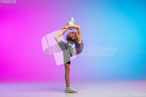 Image of Teenage girl running, jogging against gradient pink-blue neon studio background in motion