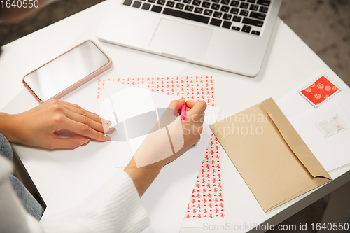 Image of Woman making greeting card for New Year and Christmas 2021 for friends or family, scrap booking, DIY