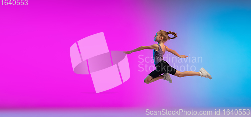 Image of Teenage girl running, jogging against gradient pink-blue neon studio background in motion