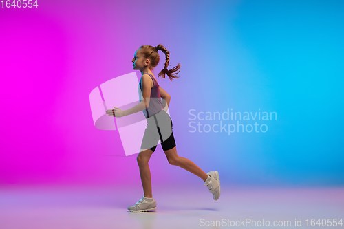 Image of Teenage girl running, jogging against gradient pink-blue neon studio background in motion