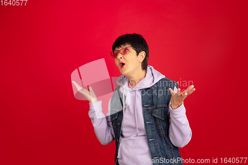 Image of Senior woman isolated on red background. Tech and joyful elderly lifestyle concept