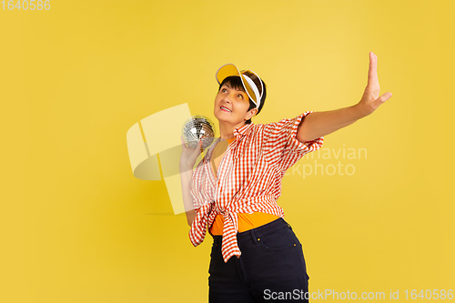 Image of Senior woman isolated on yellow background. Tech and joyful elderly lifestyle concept