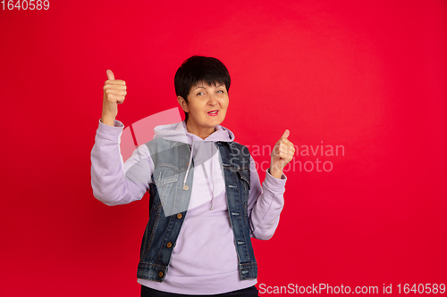 Image of Senior woman isolated on red background. Tech and joyful elderly lifestyle concept