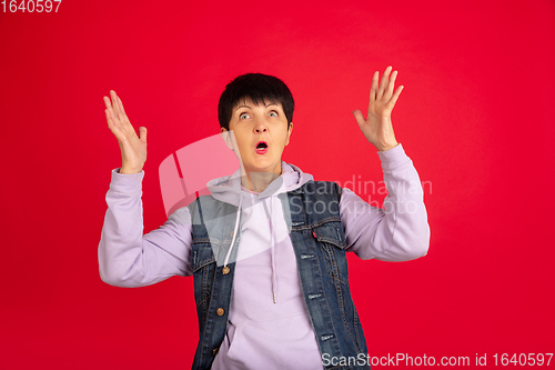 Image of Senior woman isolated on red background. Tech and joyful elderly lifestyle concept