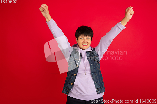 Image of Senior woman isolated on red background. Tech and joyful elderly lifestyle concept