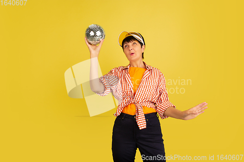 Image of Senior woman isolated on yellow background. Tech and joyful elderly lifestyle concept