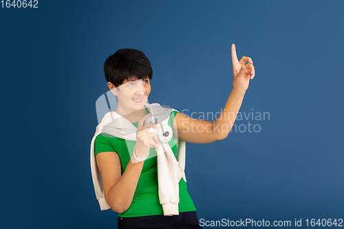 Image of Senior woman isolated on blue background. Tech and joyful elderly lifestyle concept