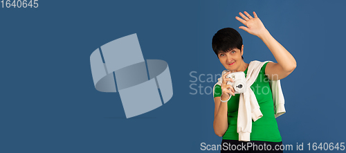 Image of Senior woman isolated on blue background. Tech and joyful elderly lifestyle concept