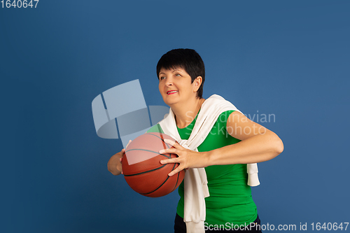 Image of Senior woman isolated on blue background. Tech and joyful elderly lifestyle concept
