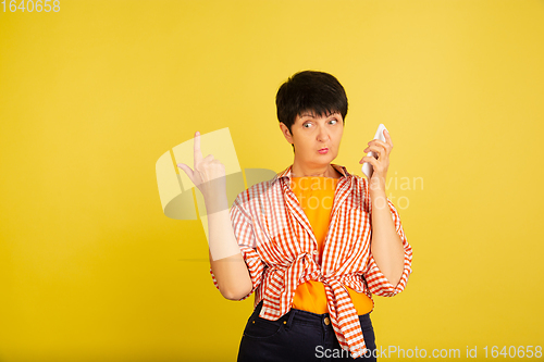 Image of Senior woman isolated on yellow background. Tech and joyful elderly lifestyle concept