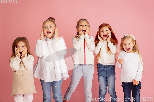 Image of Portrait of little caucasian children with bright emotions isolated on pink studio background