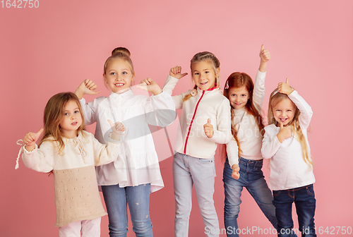 Image of Portrait of little caucasian children with bright emotions isolated on pink studio background