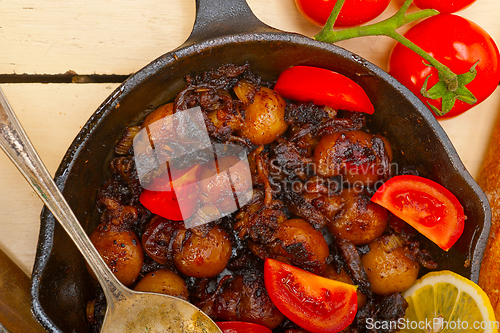 Image of Baby cuttle fish roasted on iron skillet