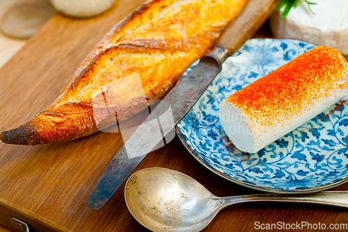 Image of French cheese and fresh  baguette on a wood cutter