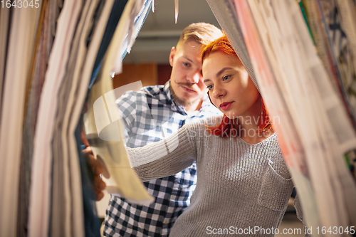 Image of Couple choosing textile at home decoration store, shop. Making of home interior design during quarantine