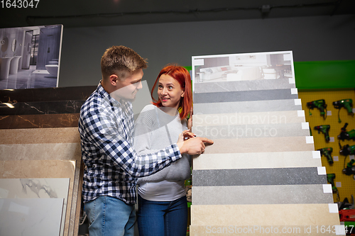 Image of Couple choosing textile at home decoration store, shop. Making of home interior design during quarantine