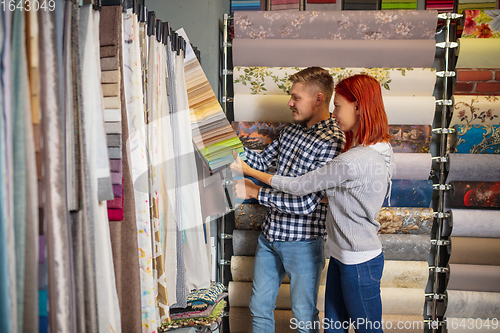 Image of Couple choosing textile at home decoration store, shop. Making of home interior design during quarantine